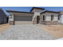 Beautiful, modern home featuring a two-car garage and stone accents at 11996 N Luckenbach St, Surprise, AZ 85388
