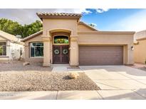 Charming home with tile roof, desert landscaping, and a decorative double door entrance at 1447 E Nighthawk Way, Phoenix, AZ 85048