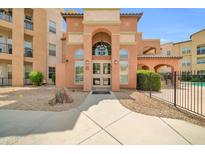 Inviting multi-story building featuring stucco walls, arched entryway, and manicured desert landscaping at 14575 W Mountain View Blvd # 11315, Surprise, AZ 85374