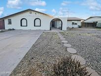 Charming single-story home featuring a white brick facade and a well-maintained front yard with stone walkway at 17405 N 19Th Dr, Phoenix, AZ 85023