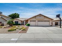 Charming single-story home with a three-car garage and a well-manicured desert front yard at 17500 N 85Th Dr, Peoria, AZ 85382