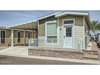 Charming home exterior featuring a covered parking area and a welcoming front porch with white railing at 2206 S Ellsworth Rd # 129B, Mesa, AZ 85201