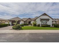 Charming home with a well-manicured lawn, mature landscaping, and a two-car garage at 2949 E Athena Ave, Gilbert, AZ 85297