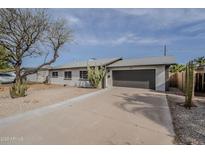 Charming single-story home with desert landscaping, attached two-car garage, and a long concrete driveway at 3220 E Andorra Dr, Phoenix, AZ 85032