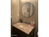Bathroom vanity features a round mirror, granite countertop, and stylish faucet at 4242 N 27Th St # 2, Phoenix, AZ 85016