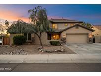 Charming home exterior at dusk featuring a well-maintained yard and attached two-car garage at 7238 W El Cortez Pl, Peoria, AZ 85383