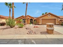Charming single-story home boasts a xeriscaped front yard, desert landscaping, and a two-car garage at 15834 W Avalon Dr, Goodyear, AZ 85395