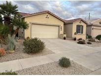 Charming home featuring a desert landscaped front yard, a neutral color palette, and a spacious two car garage at 172 S Agua Fria Ln, Casa Grande, AZ 85194