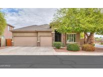 Charming single-story home with a three-car garage and well-manicured landscaping at 20583 N Ryans Trl, Maricopa, AZ 85138