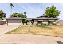 Charming single-story brick home with a well-manicured front lawn and mature trees at 2816 S Don Luis Cir, Mesa, AZ 85202