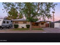 Charming single-story home featuring a covered porch and carport, complemented by mature landscaping and RV parking at 4527 N 12Th Ave, Phoenix, AZ 85013