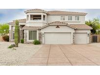 Two-story home features a tile roof, stone accents, a three-car garage, and desert landscaping at 6916 E Trailridge Cir, Mesa, AZ 85207