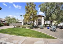 Charming home with beautifully landscaped front yard, mature trees and a welcoming facade at 9760 E San Salvador Dr, Scottsdale, AZ 85258