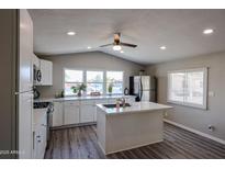 Bright kitchen featuring white cabinets, stainless steel appliances, kitchen island, and lots of natural light at 11275 N 99Th Ave # 170, Peoria, AZ 85345