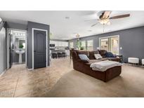 Comfortable living room featuring a plush brown sofa, ceiling fan, and tile flooring at 11737 W Robin Dr, Sun City, AZ 85373