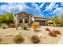 Charming home featuring desert landscaping, a two-car garage, and a beautiful tiled roof, offering great curb appeal at 18502 N 98Th Way, Scottsdale, AZ 85255