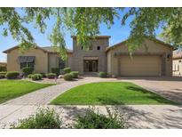 Charming single-story home featuring a well-manicured lawn, lush greenery, and a brick pathway leading to the front door at 2873 E Los Altos Rd, Gilbert, AZ 85297