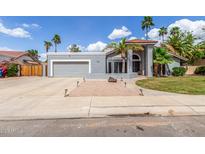 Charming single-story home featuring mature palms, a two-car garage, and desert landscaping at 412 W Curry St, Chandler, AZ 85225