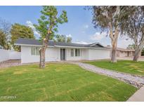 Charming single-story home with a well-manicured lawn and stone pathway at 711 N 22Nd St, Mesa, AZ 85213