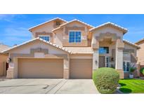 Charming two-story home featuring a three-car garage and well-manicured front yard, set against a bright blue sky at 740 N Bradley Dr, Chandler, AZ 85226