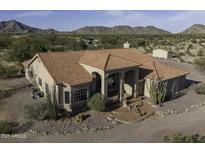 Expansive view of a desert home with red tile roof, desert landscaping, and views of the surrounding mountains at 9690 W Martin Rd, Casa Grande, AZ 85194