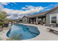 Inviting backyard pool with lounge area and covered patio, perfect for outdoor entertaining at 19633 N 264Th Ave, Buckeye, AZ 85396