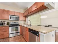 Efficient kitchen with stainless steel appliances, granite countertops, and wooden cabinets at 5345 E Van Buren St # 258, Phoenix, AZ 85008