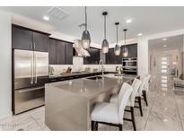 Spacious kitchen featuring a large island with seating, stainless steel appliances, and ample cabinetry at 6908 W Jasmine Trl, Peoria, AZ 85383
