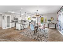 Modern kitchen features stainless steel appliances, a center island with seating, and an adjacent dining area at 8214 E Meadowbrook Ave, Scottsdale, AZ 85251