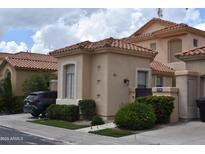 Attractive single-story home with a terracotta roof and landscaped front yard, and a dark SUV parked in the driveway at 11390 N 78Th St, Scottsdale, AZ 85260