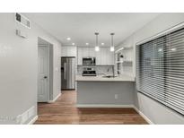 Bright kitchen featuring stainless steel appliances, white cabinets, and a marble-look countertop with pendant lighting at 1432 W Emerald Ave # 648, Mesa, AZ 85202
