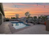 Inviting backyard pool with lounge chairs and string lights, perfect for relaxing evenings at 1694 E Mia Ln, Gilbert, AZ 85298