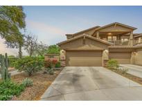 Inviting two-story home featuring a two-car garage and desert landscaping in front at 1945 W Desert Vista Trl # 81, Phoenix, AZ 85085