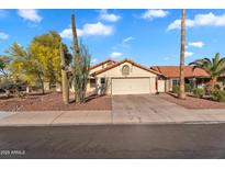 Charming single-story home features a tile roof, desert landscaping, and a two-car garage at 2218 E Desert Trumpet Rd, Phoenix, AZ 85048