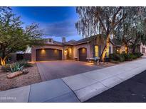 Attractive home featuring a three-car garage, brick driveway, neutral stucco, and manicured landscaping at 25929 N 84Th Ln, Peoria, AZ 85383