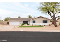 Charming single-story home featuring a well-maintained yard, a garage, and appealing desert landscaping at 2710 E Cinnabar Ave, Phoenix, AZ 85028