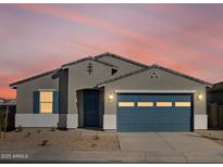 Charming single-story home featuring a blue garage door, shuttered window and neutral stucco at 37458 W San Clemente St, Maricopa, AZ 85138