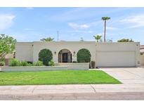 Charming single-story home featuring an arched entryway, mature landscaping, and attached two-car garage at 9019 N 87Th Way, Scottsdale, AZ 85258