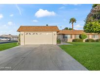 Charming single-story home featuring a well-manicured lawn and a spacious two-car garage at 9202 N 107Th Ave, Sun City, AZ 85351