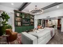 Spacious living room featuring custom green built-ins and a decorative chandelier at 1025 E Northern Ave, Phoenix, AZ 85020