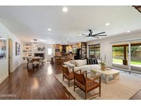 Bright open-concept living room with hardwood floors, and seamless flow to a modern kitchen and outdoor patio at 10896 N 105Th Way, Scottsdale, AZ 85259