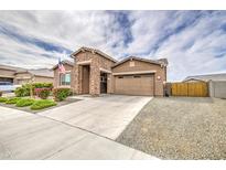 Charming single-Gathering home featuring a stone facade, two-car garage, and well-manicured landscaping at 19742 W Harrison St, Buckeye, AZ 85326