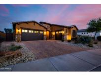 Beautiful stucco home with stone accents, large driveway, and three-car garage at dusk at 2361 N 156Th Dr, Goodyear, AZ 85395