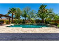 Beautiful backyard pool features lush tropical landscaping and a basketball hoop for outdoor fun at 2361 N 156Th Dr, Goodyear, AZ 85395