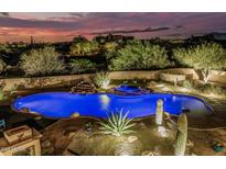 Inviting pool and spa with water feature amidst desert landscaping, beautifully lit at twilight at 30330 N 77Th Pl, Scottsdale, AZ 85266