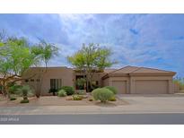 Attractive one-story home featuring desert landscaping, a tile roof, and an attached two-car garage at 33242 N 68Th Pl, Scottsdale, AZ 85266