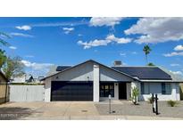 Charming single-story home showcasing a brick facade, modern garage door, and solar panels against a vibrant sky at 4038 W Windrose Dr, Phoenix, AZ 85029