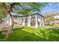 Expansive backyard featuring a covered patio, lush lawn, and mature trees, creating a serene outdoor oasis at 541 W Palm Ln, Phoenix, AZ 85003