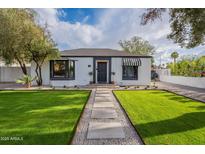 Charming single-story home with lush green lawn, stone pathway, and classic architectural details at 541 W Palm Ln, Phoenix, AZ 85003