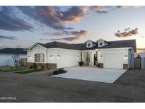 Stunning white home featuring a three car garage, stone accents, and beautiful curb appeal at 6244 S Flora Ln, Gold Canyon, AZ 85118